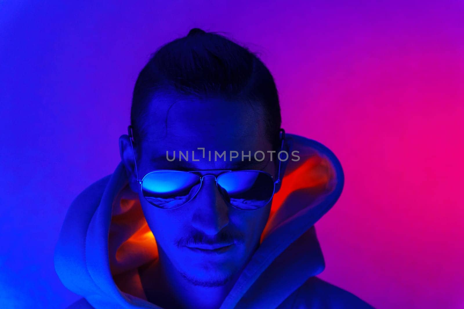 Portrait of a young man in profile at studio. Male model in colorful bright neon lights posing on purple background by darksoul72