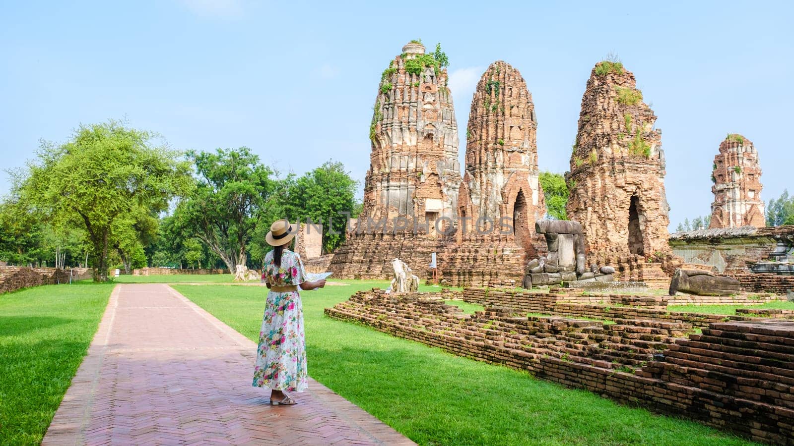 Ayutthaya Thailand, Wat Mahathat, women with a hat, and tourist maps visiting Ayutthaya Thailand. Tourists with a map of Thailand