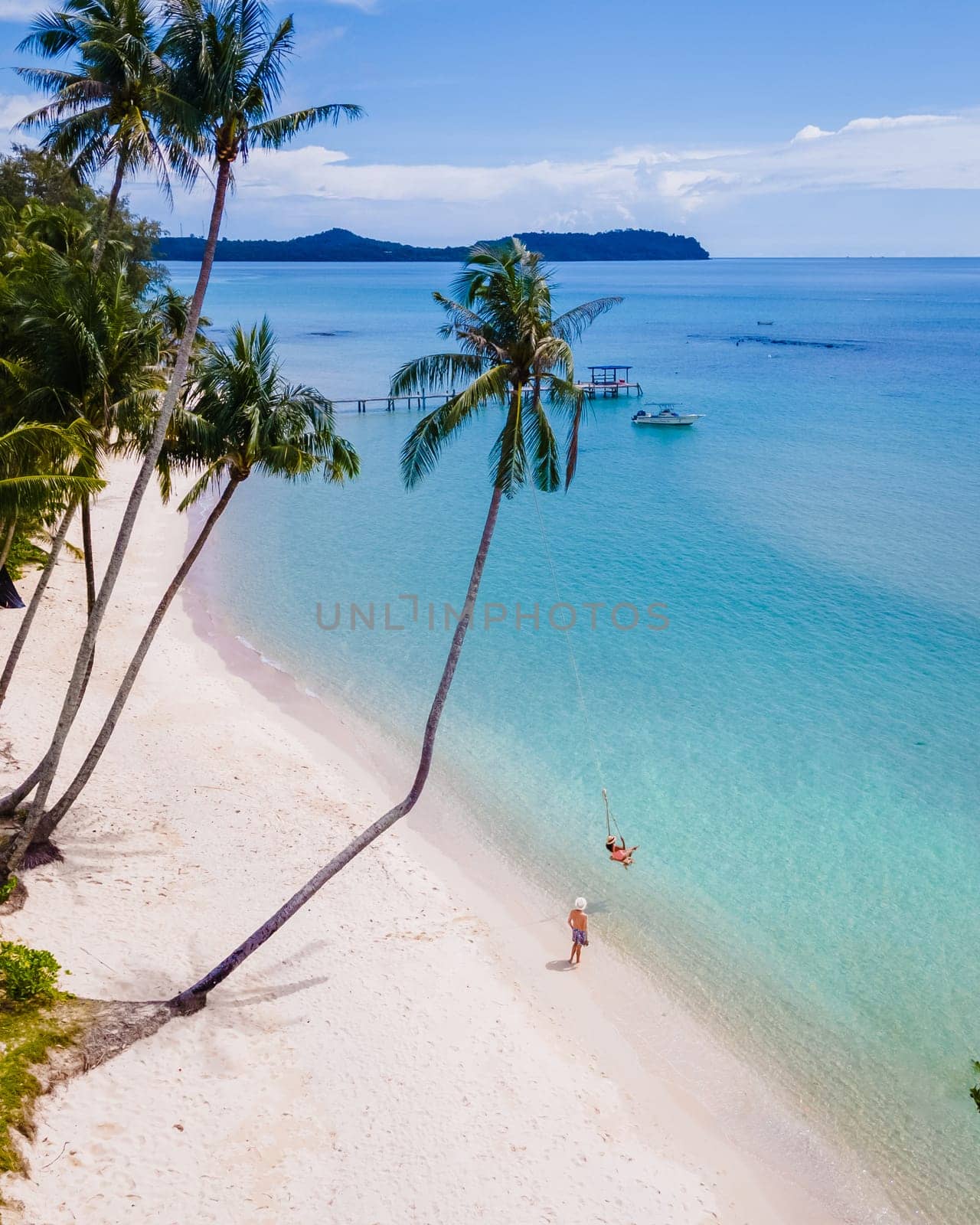 Tropical Island Koh Kood or Koh Kut Thailand. Couple men and women on vacation in Thailand playing with a swing on the beach, holiday concept Island hopping in Eastern Thailand Trang