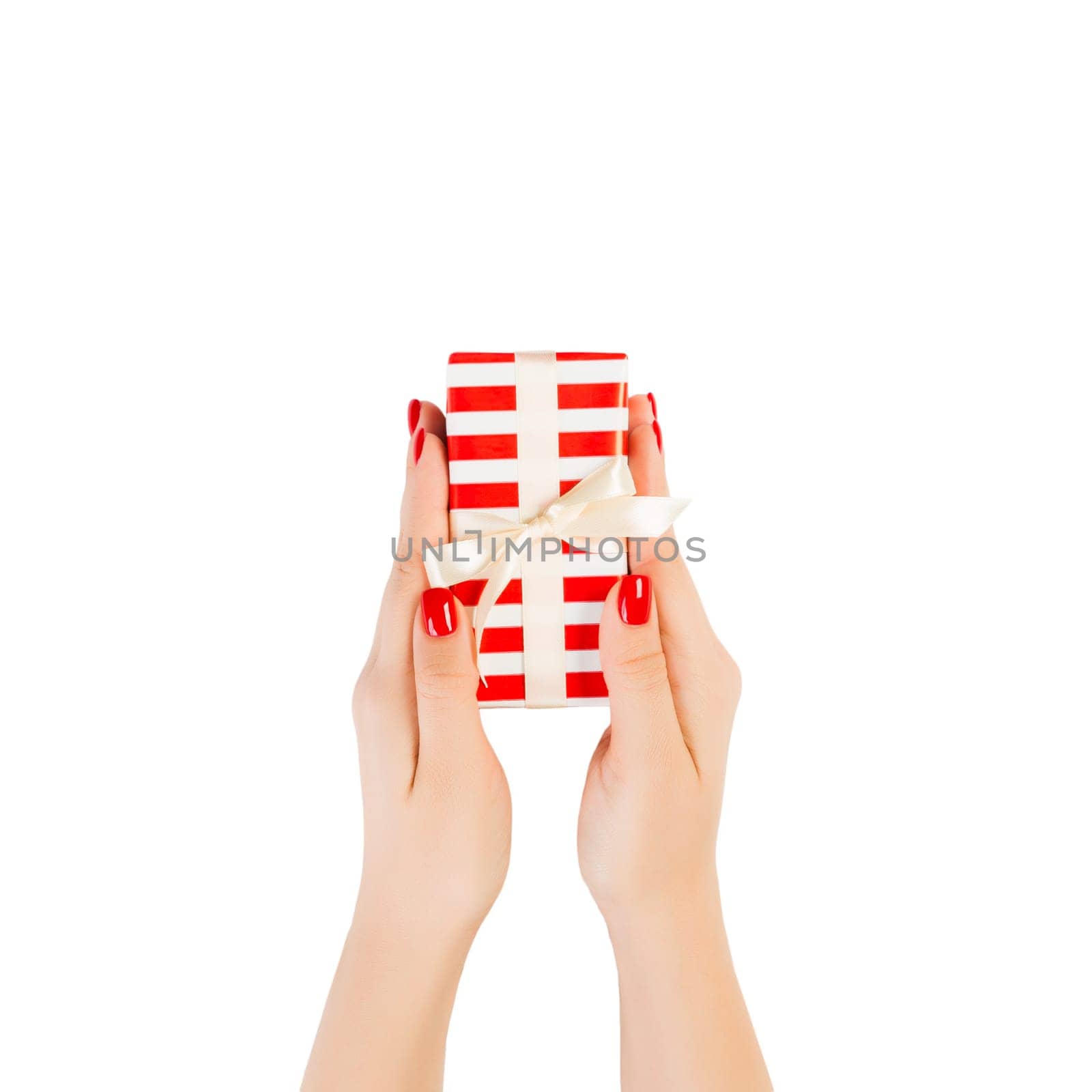 Woman hands give wrapped Christmas or other holiday handmade present in red paper with gold ribbon. Isolated on white background, top view. thanksgiving Gift box concept.