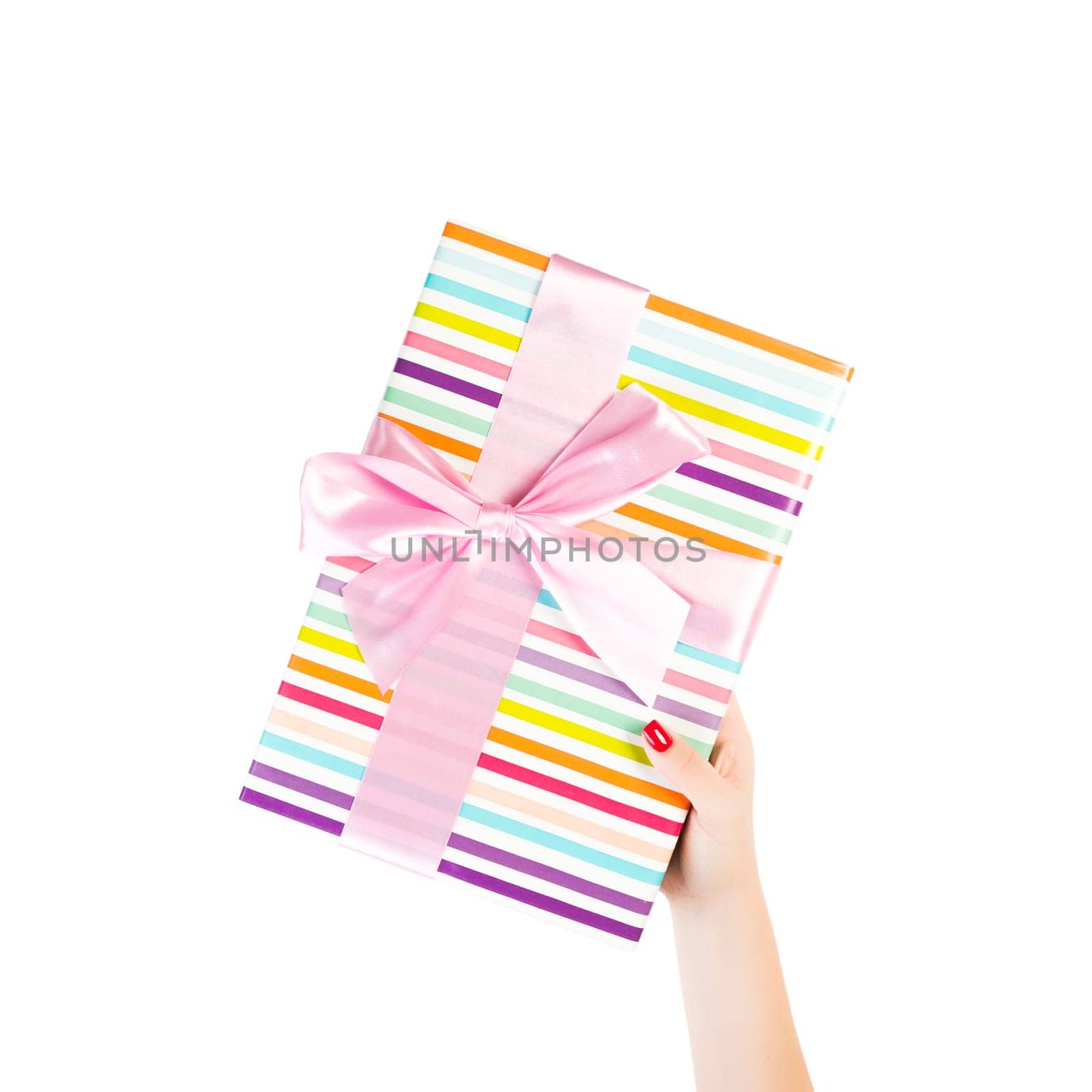 Woman hands give wrapped Christmas or other holiday handmade present in colored paper with pink ribbon. Isolated on white background, top view. thanksgiving Gift box concept.