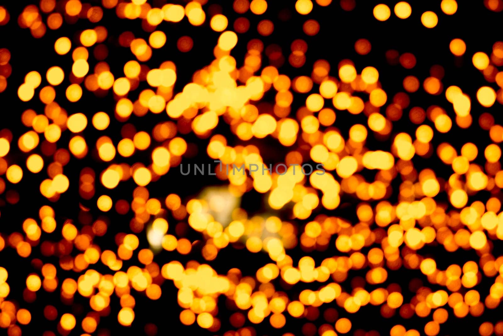 Unfocused abstract gold bokeh on black background. defocused and blurred many round light.