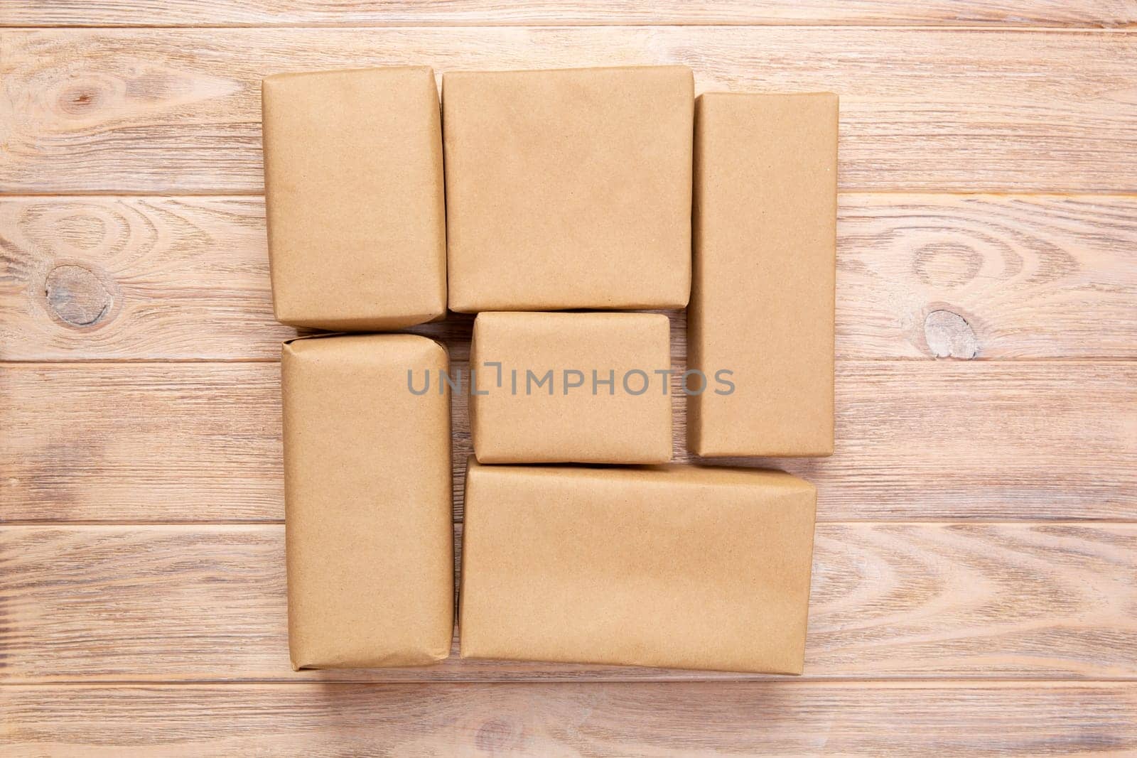 Brown mail package parcel blank for you design. Cardboard box on a wooden background.