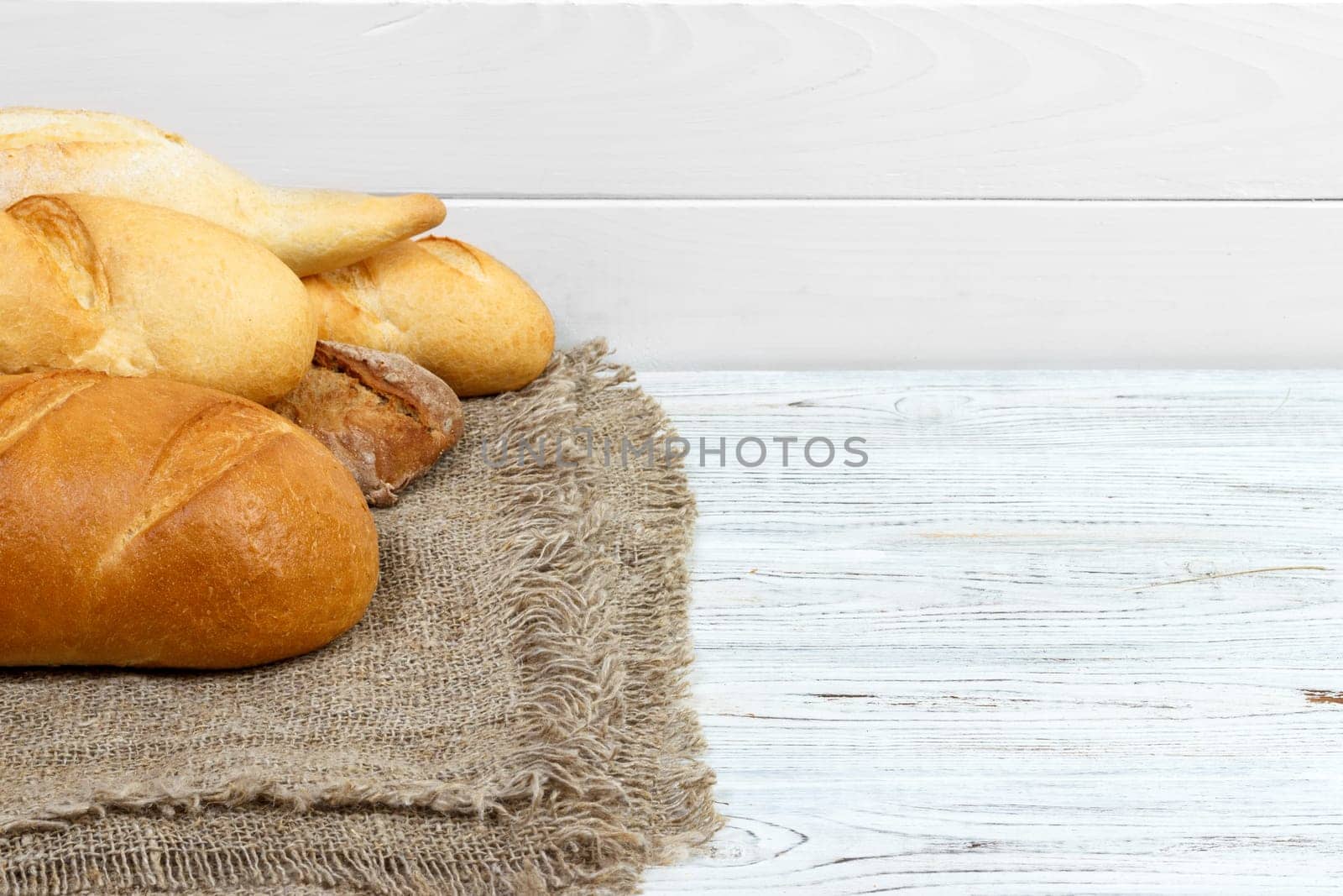 Bread baguettes on rustic white painted wood.