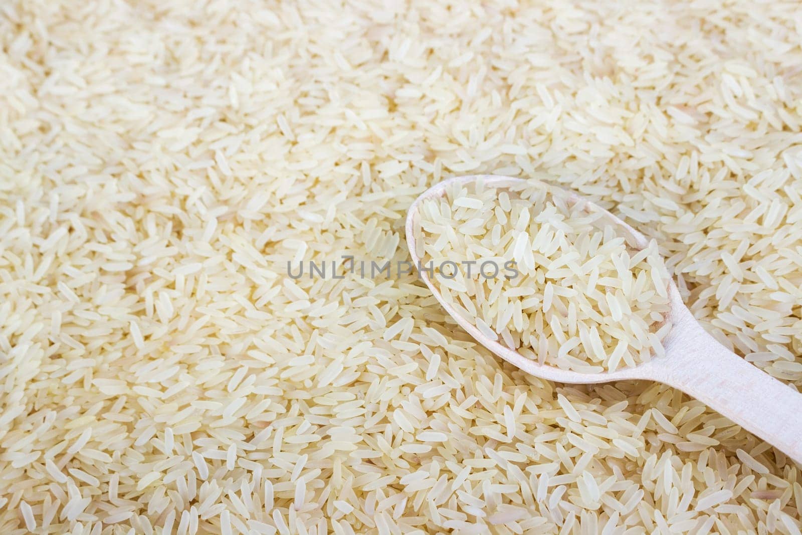 Rice in a wooden spoon. close up of white rice cereal