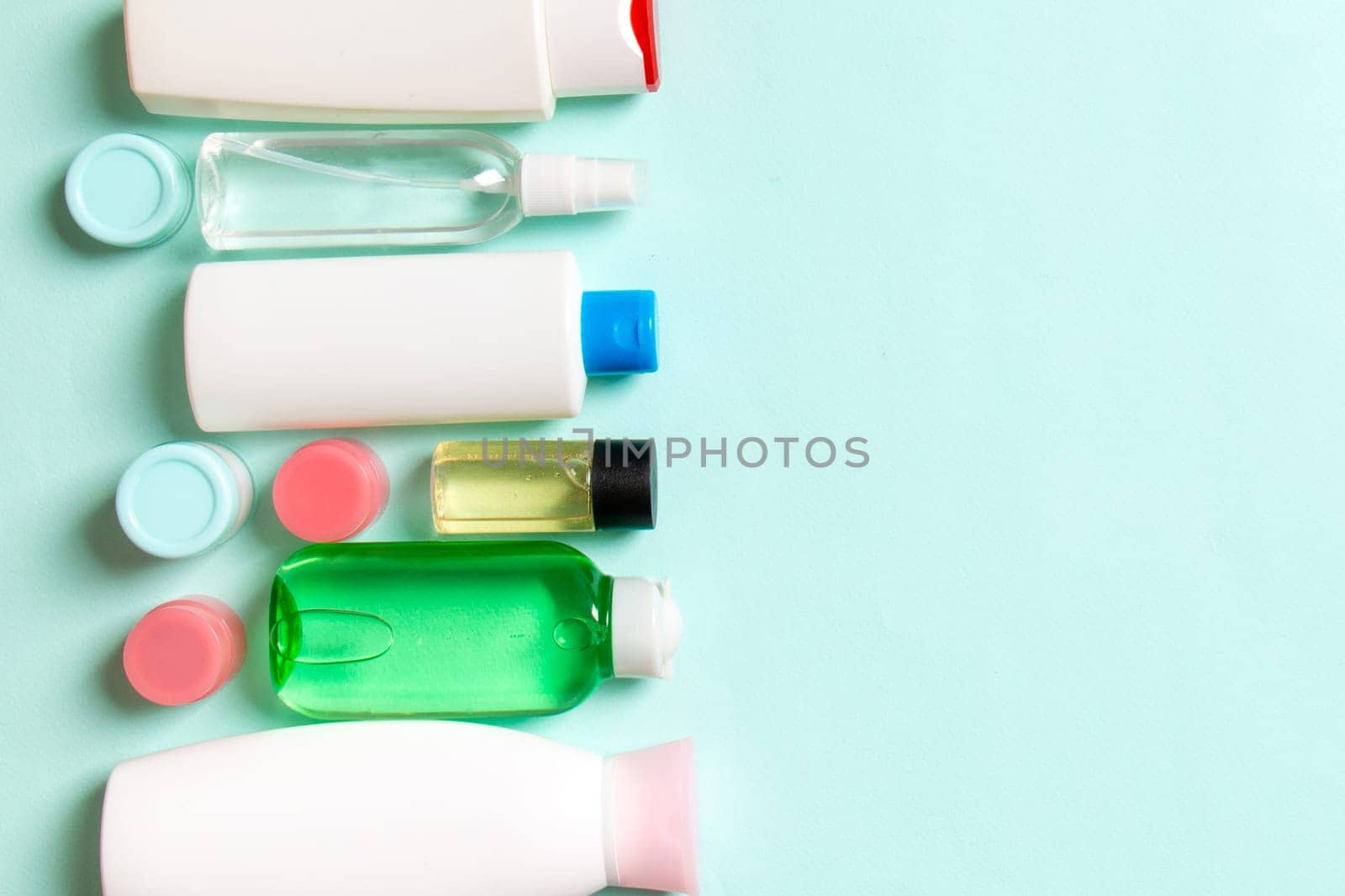Top view of cosmetic products in different jars and bottles on colored background. Close-up of containers with copy space by Snegok1967