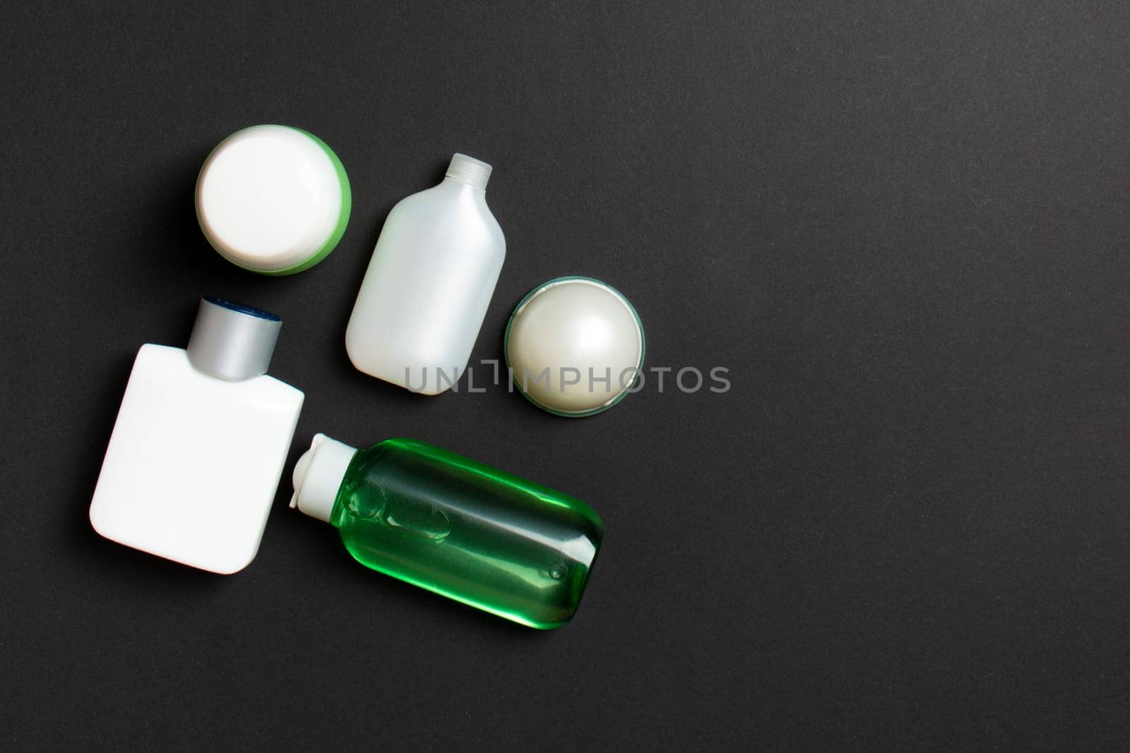 Cosmetics SPA branding mock-up, top view with copy space. set of tubes and jars of cream flat lay on colored background.