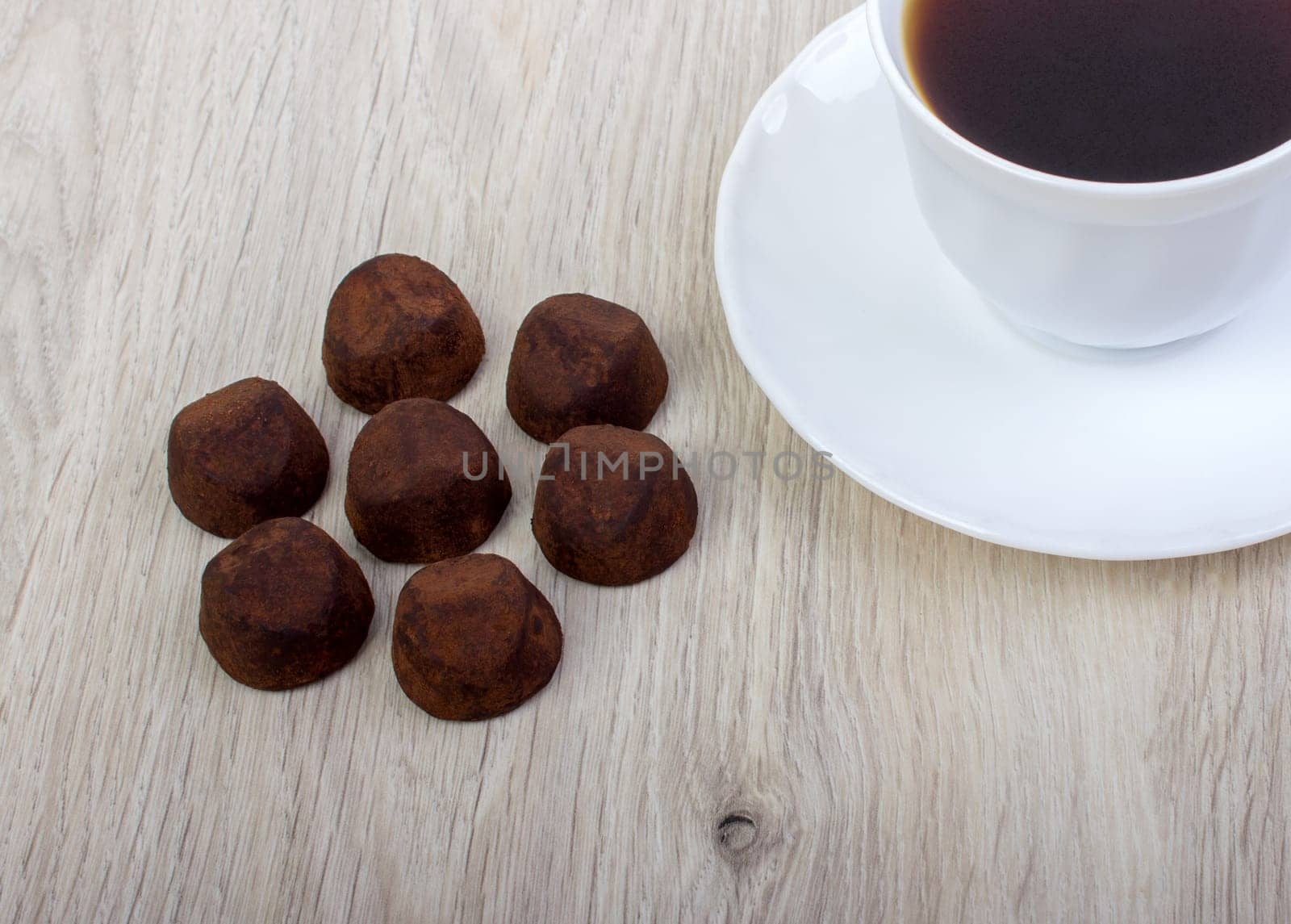 dessert truffle cocoa and coffee cup on a wooden table.