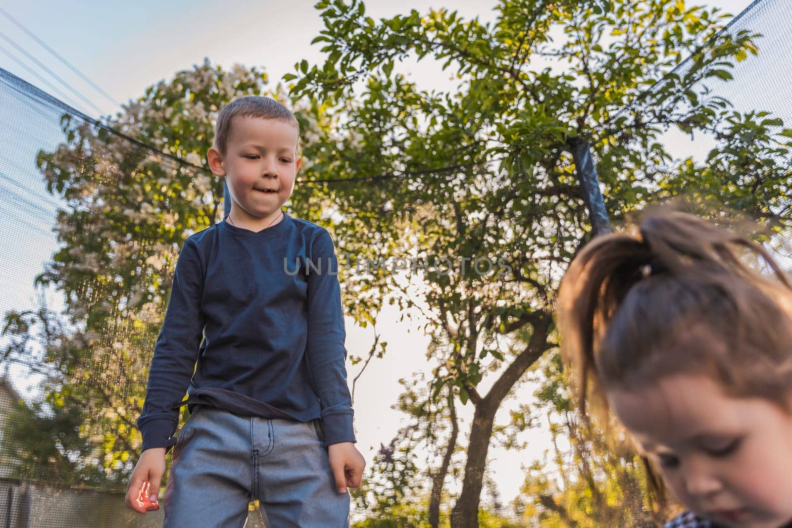 children jump on a trampoline which is outdoors