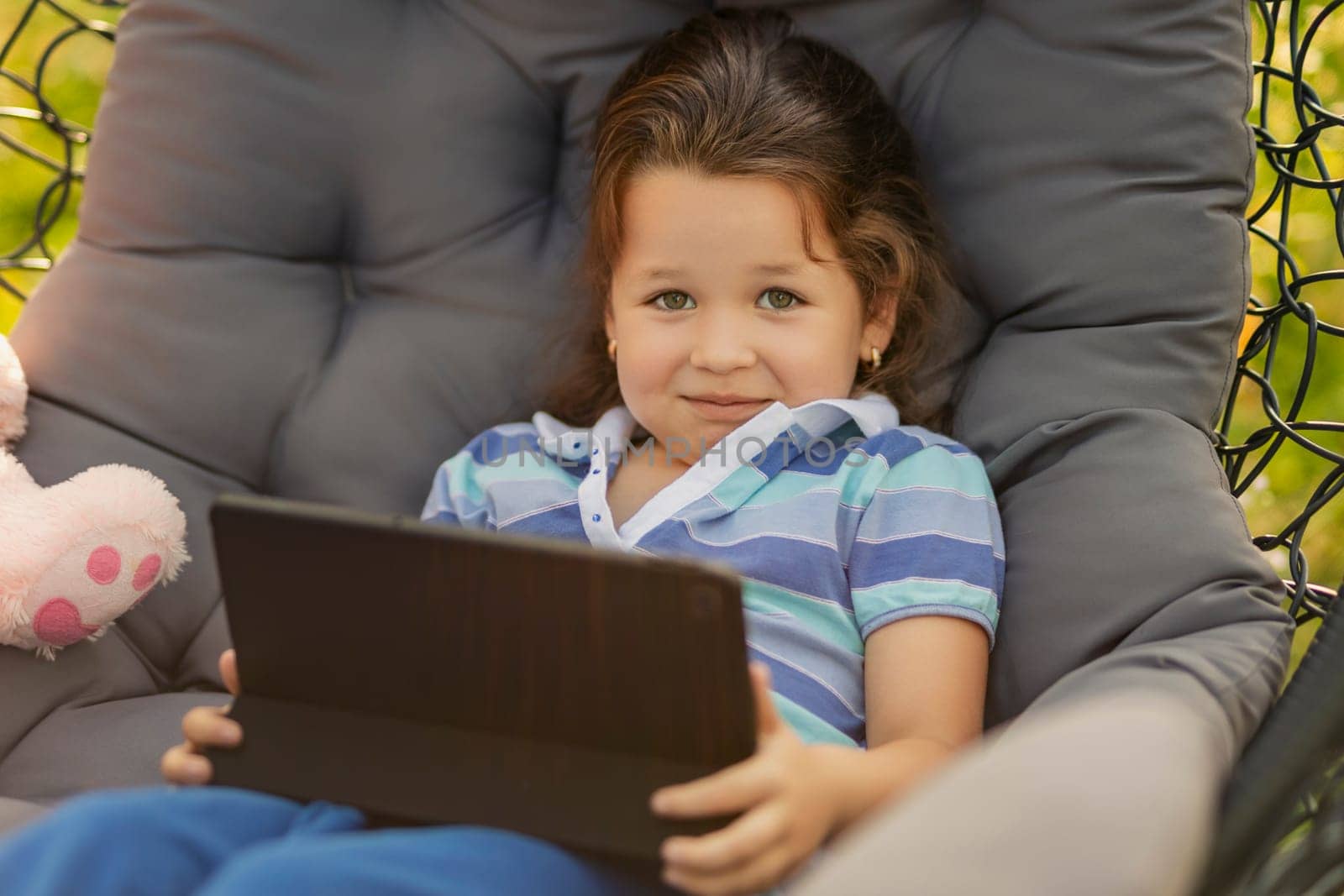 girl holding a tablet while relaxing in nature