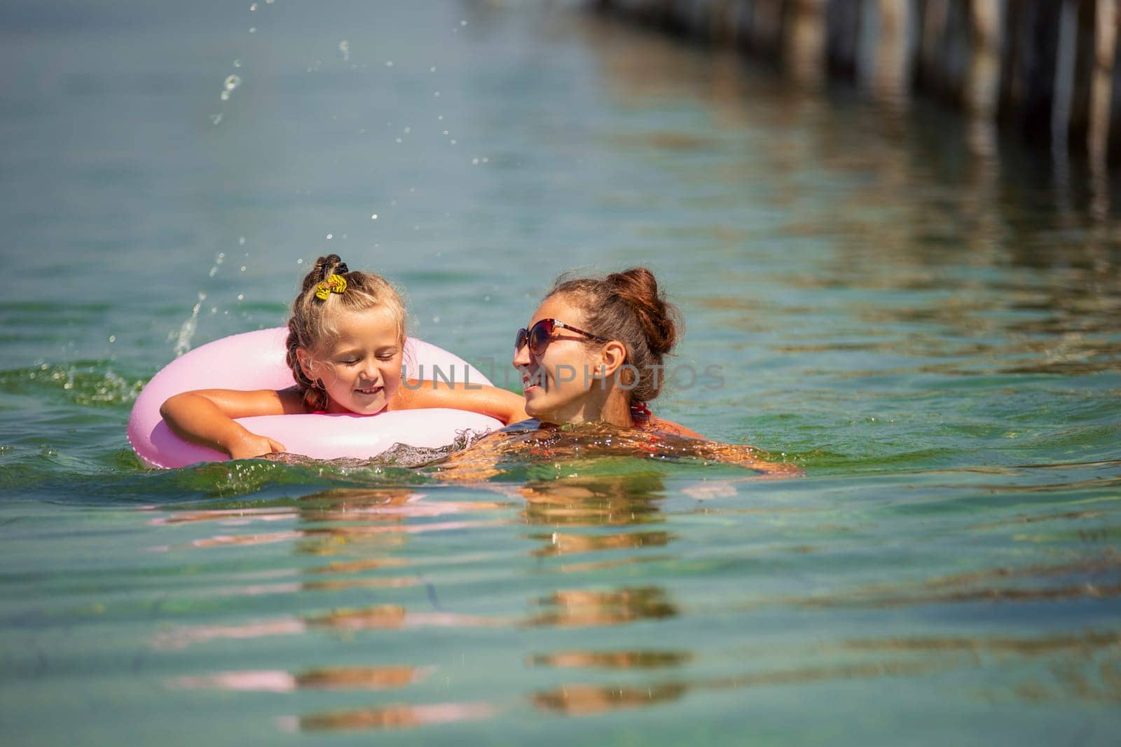 mother and daughter swimming in the sea by zokov