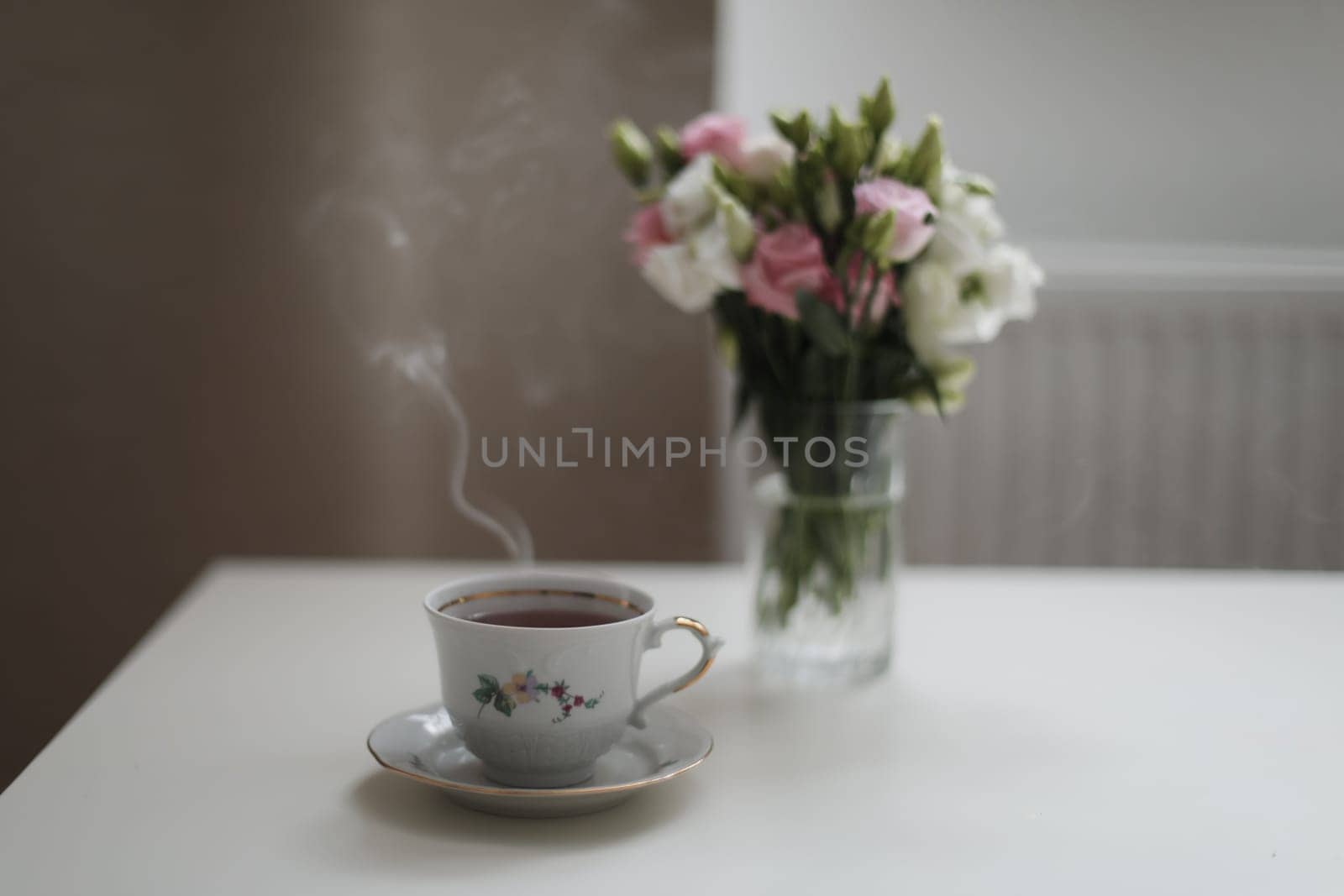 Home still life scene. Cup of coffee or tea with flowers. Vintage feminine styled photo. Floral composition, pink and white roses