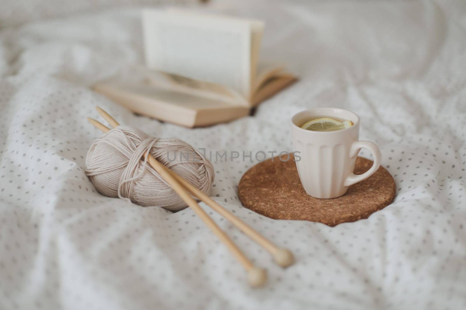 yarn and a cup of coffee on the bed. Hygge lifestyle, cozy mood. Handicraft day concept.