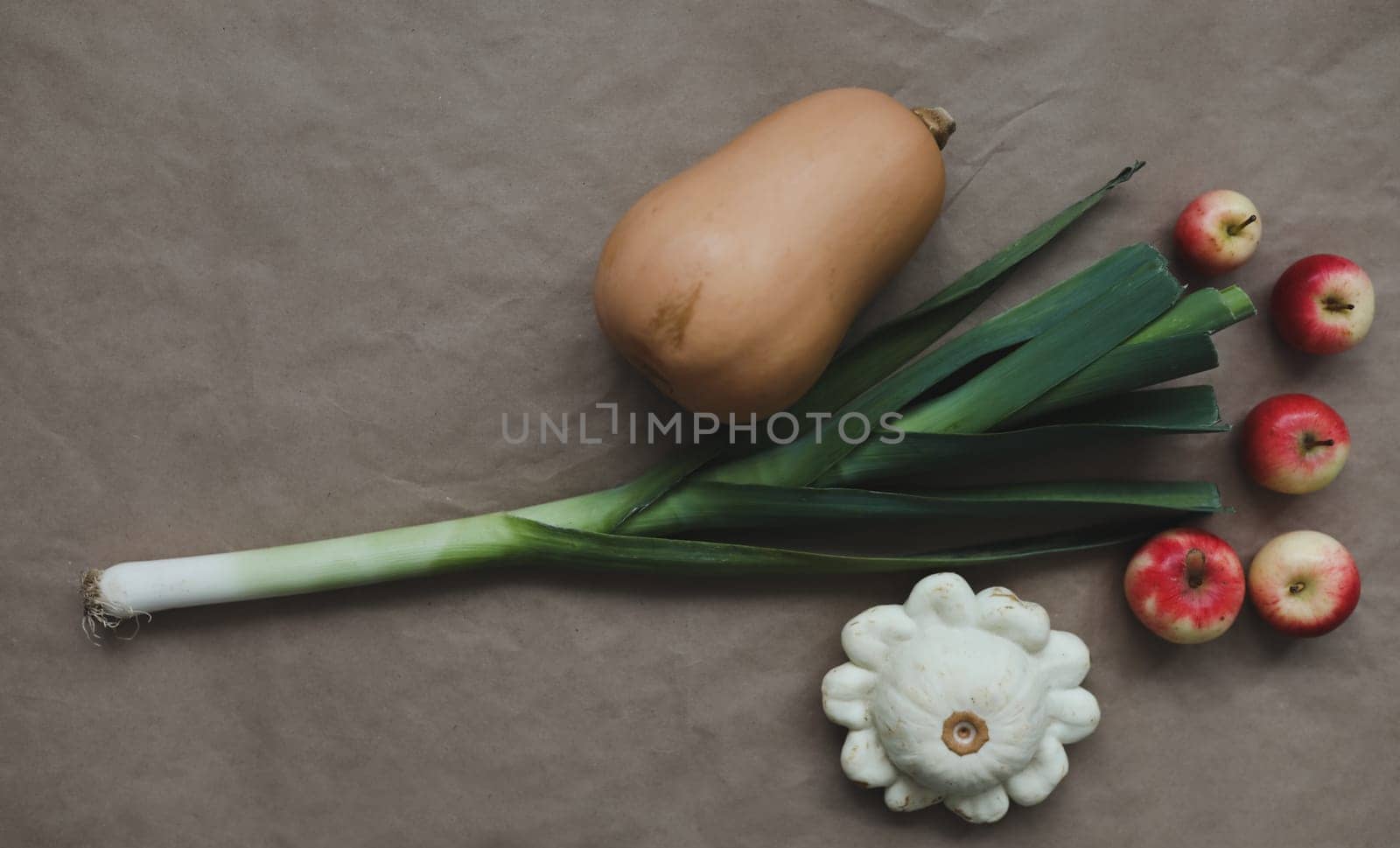 Autumn Vegetables on paper background. Pumpkin, onion, apples creative arrangement. Healthy eating concept. Flat lay, top view. Autumn fall concept