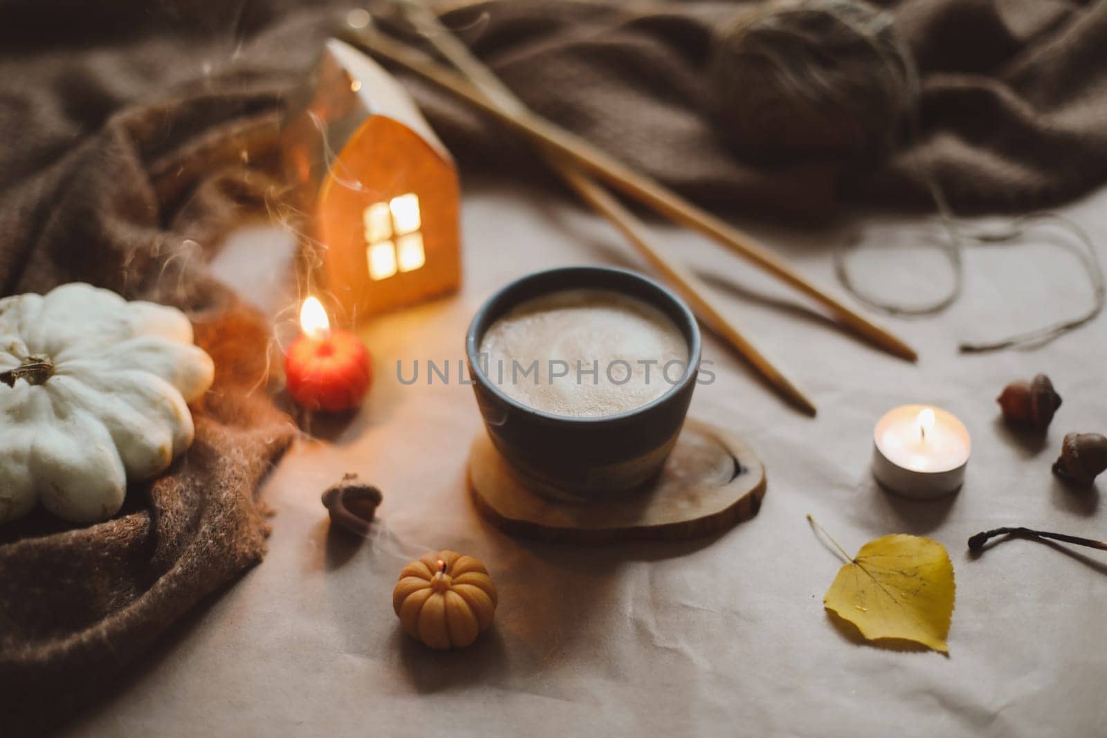 Autumn still life details in cozy home interior with a cup, candles, plaid. Hygge home decor. Halloween and Thanksgiving concept. Autumn banner