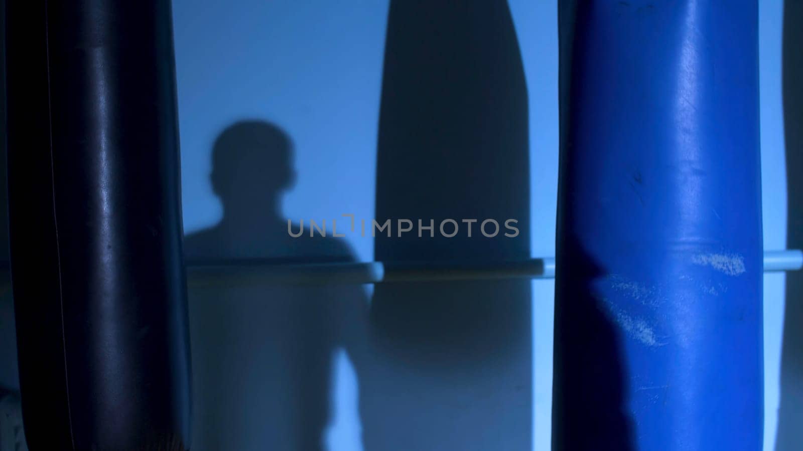 Man athlete standing and doing shadow boxing exercises in gym. Boxer doing a shadow fight.