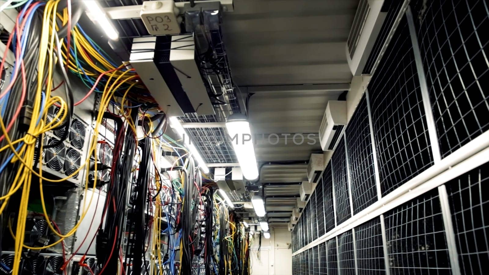 Inside room with data centers and cables. Stock footage. Room with data centers, cables and solar panels to absorb bright artificial lighting.