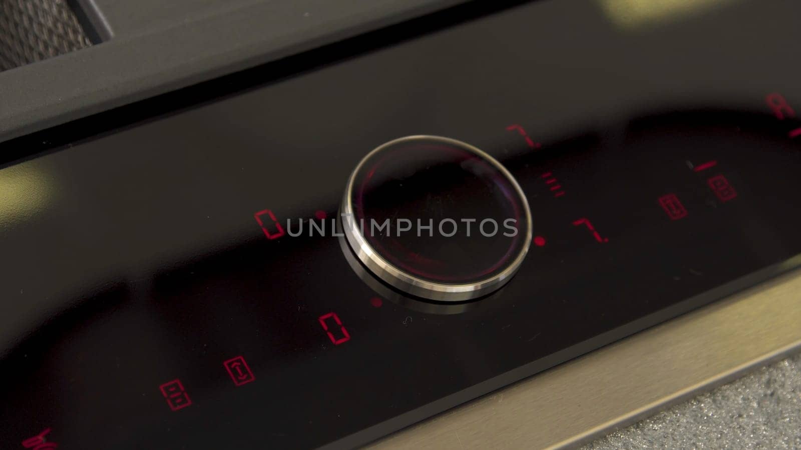 Man hand touching control panel on electric oven in the kitchen. Close up of male hand turning on and setting cooking mode on electrical hob.
