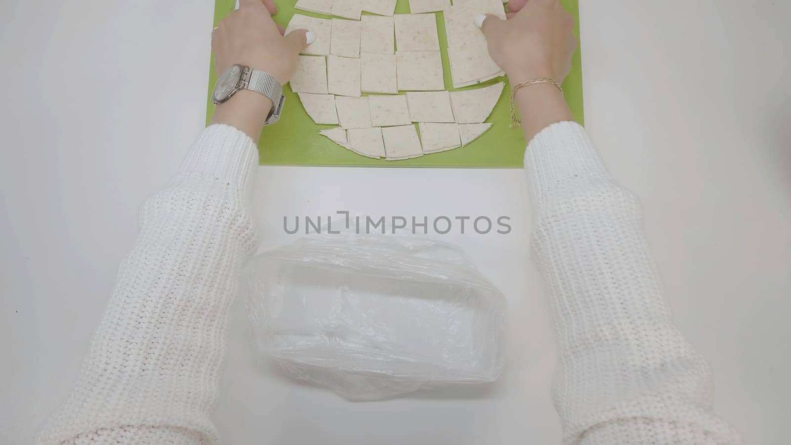 Pommes on a baking sheet. Cook puts the chips in the package. Chips on a baking sheet. Cook puts the chips on a baking sheet by Mediawhalestock