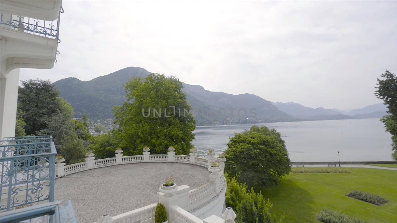 Beautiful view from the hotel balcony to the lake and lawn. Action. Warm summer day on vacation in Europe.