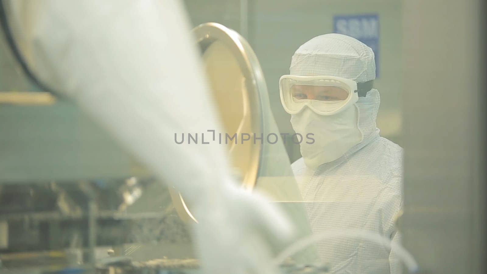 Pharmaceutical industry. Male factory worker inspecting quality of pills packaging in pharmaceutical factory. Automatic tape to create packaging and filling of medicines. control in the factory of medicine HD