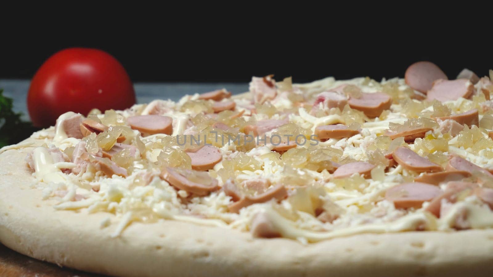 Close-up of chef preparing Italian pizza. Frame. Professional chef with gloves lay cucumber slices on pizza. Cooking Italian pizza on black isolated background.