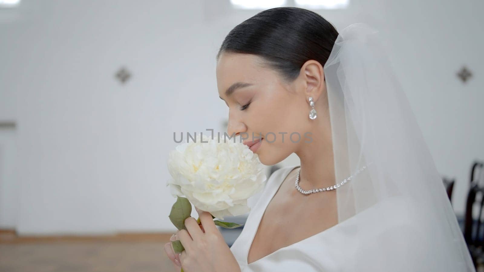 A wedding couple in a church. Action.A young couple is sitting on a decorated chair in wedding costumes and with a wedding white flower. High quality 4k footage