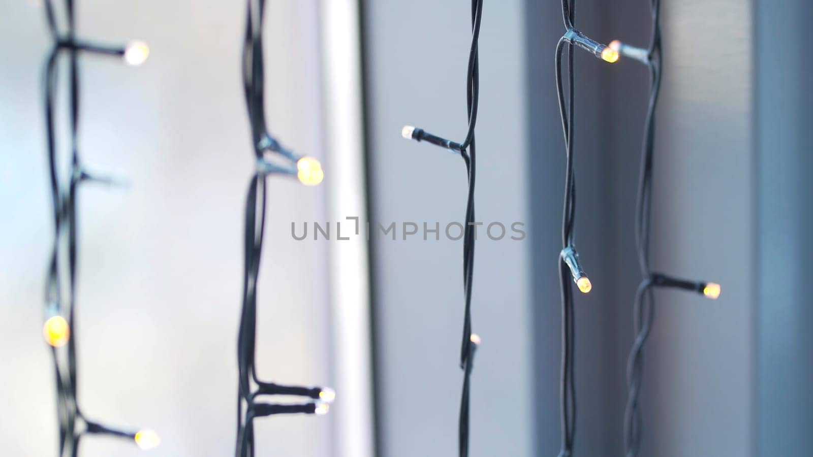 Beautiful garland with lights close up. selective focus of Christmas warm gold garland lights. Christmas lights on window background.