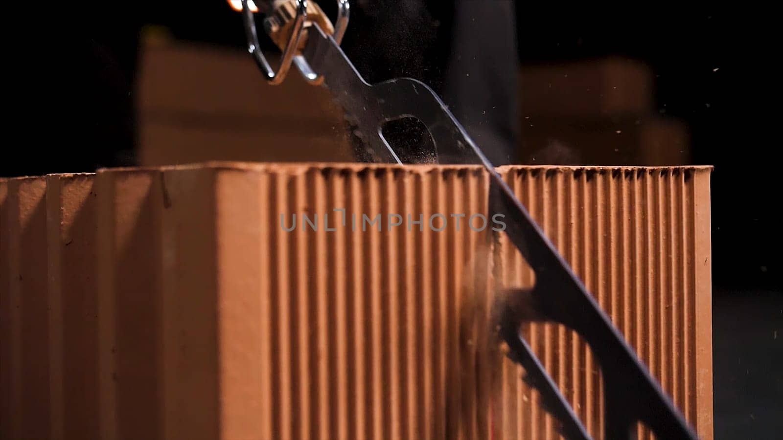 Close up of a worker using a block cutting automatic saw to prepare ceramic blocks for building process. Turned on small electric saw.