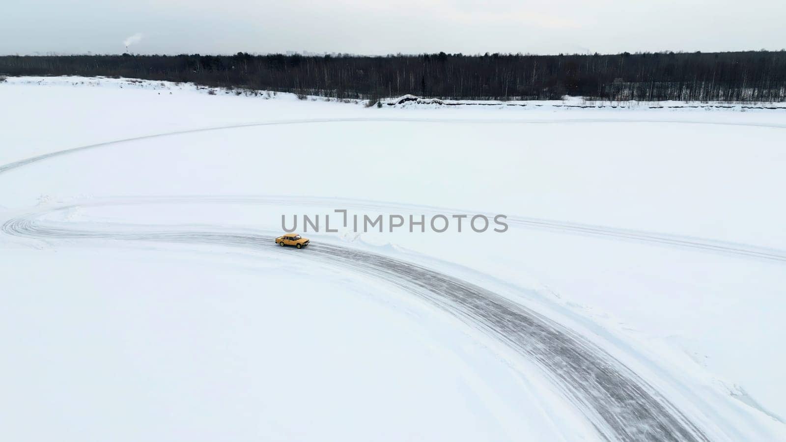 Aerial view of a race car moving fast through the snow desert. Clip. Concept of active lifestyle and sport