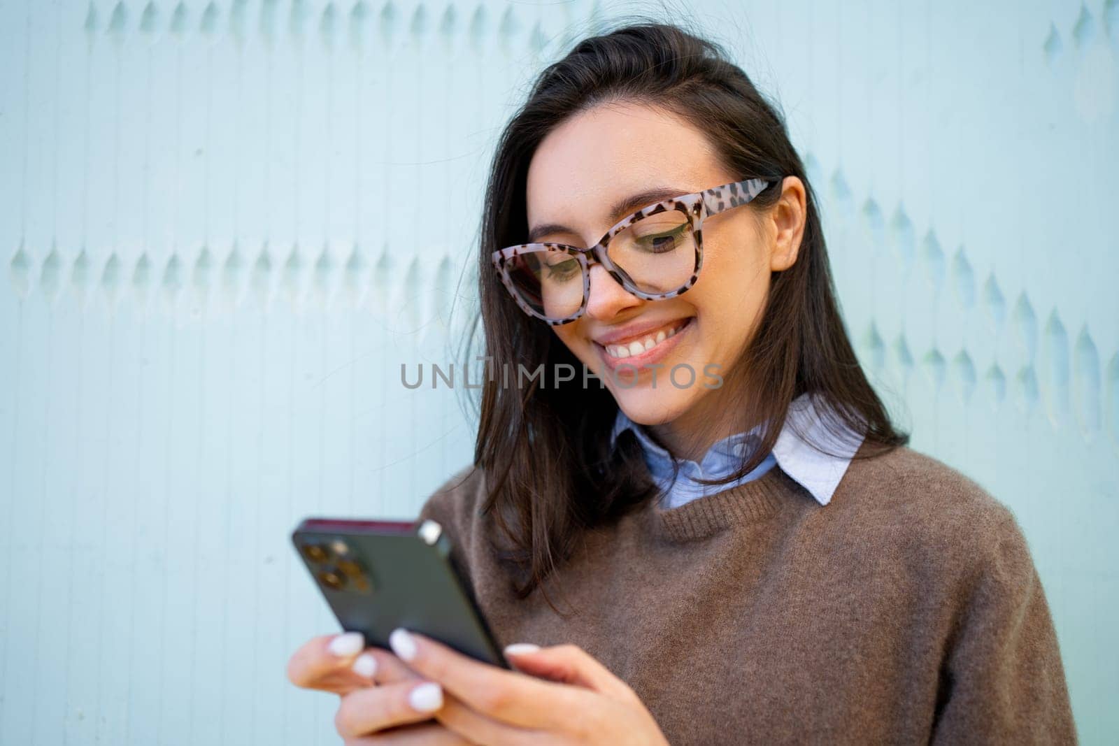 Official woman wear glasses smiles and looks at phone by andreonegin