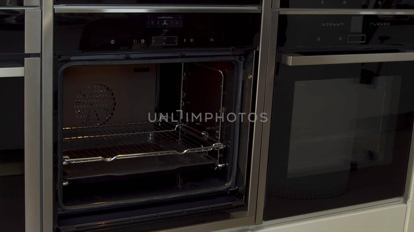 Close up of man unlocking and opening new modern mini oven for kitchen in furniture shop. Presentation of a new oven model, high tech concept.