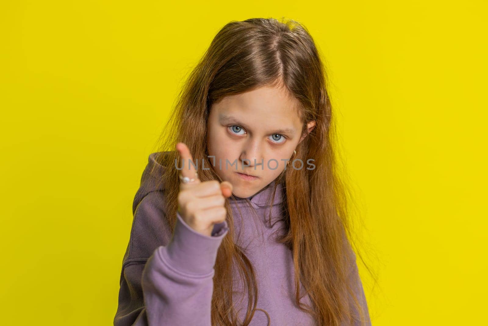 Quarrel. Portrait of displeased young school girl gesturing hands with irritation and displeasure, blaming scolding for failure asking why this happened. Preteen female child kid on yellow background