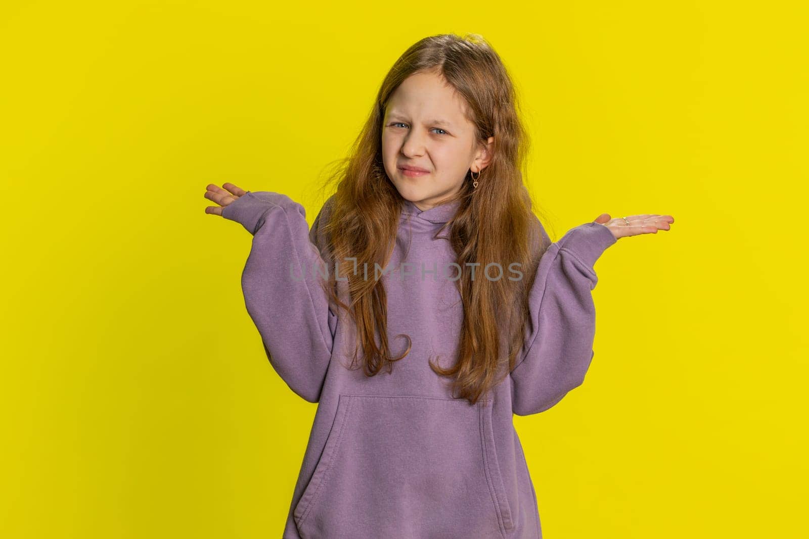What. Why. Young redhead school girl raising hands in indignant expression, asking why, what reason of failure, demonstrating disbelief irritation by troubles. Preteen child kid on yellow background