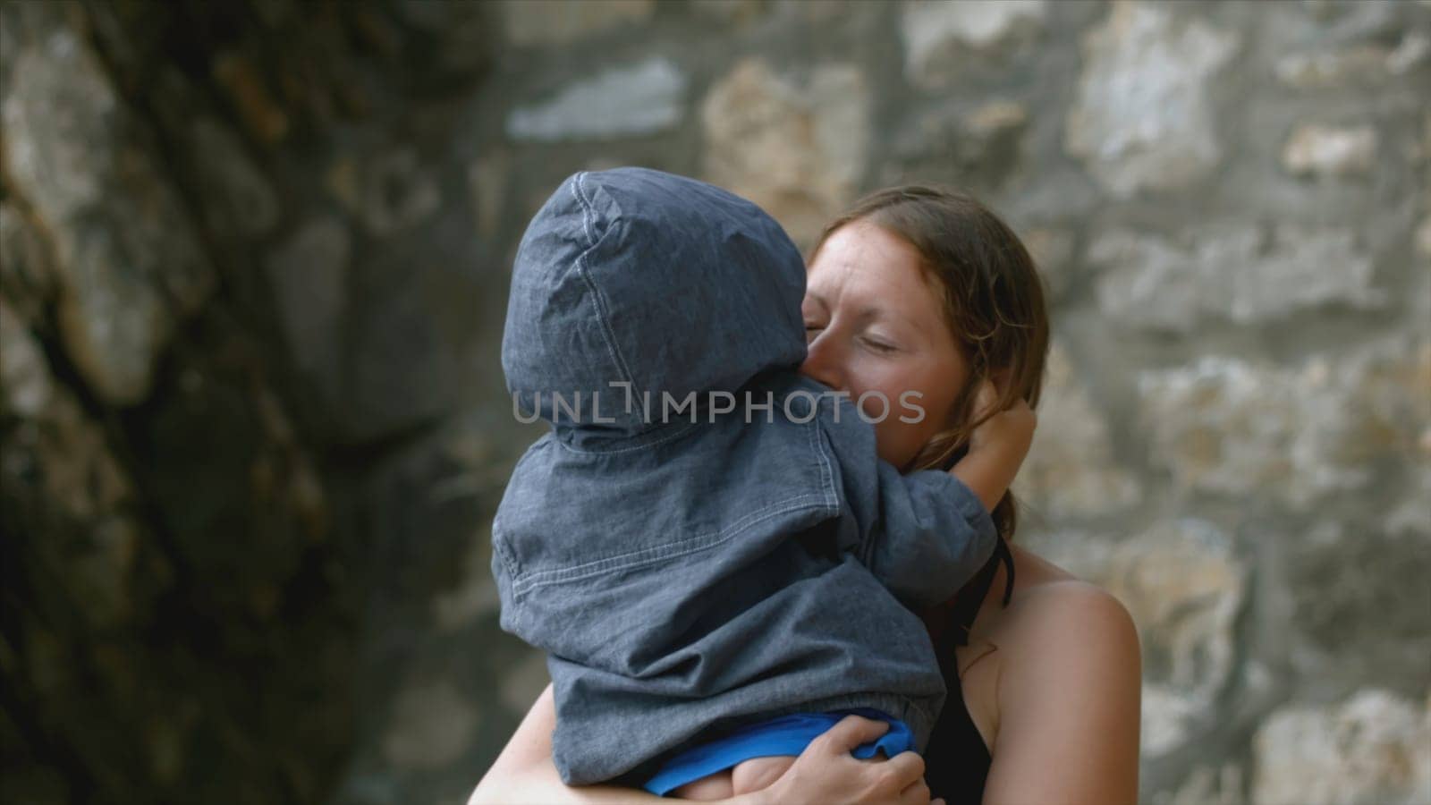 Woman hugs child on vacation. Creative. Mother and son hug in nature. Mom happily hugs little naughty son.