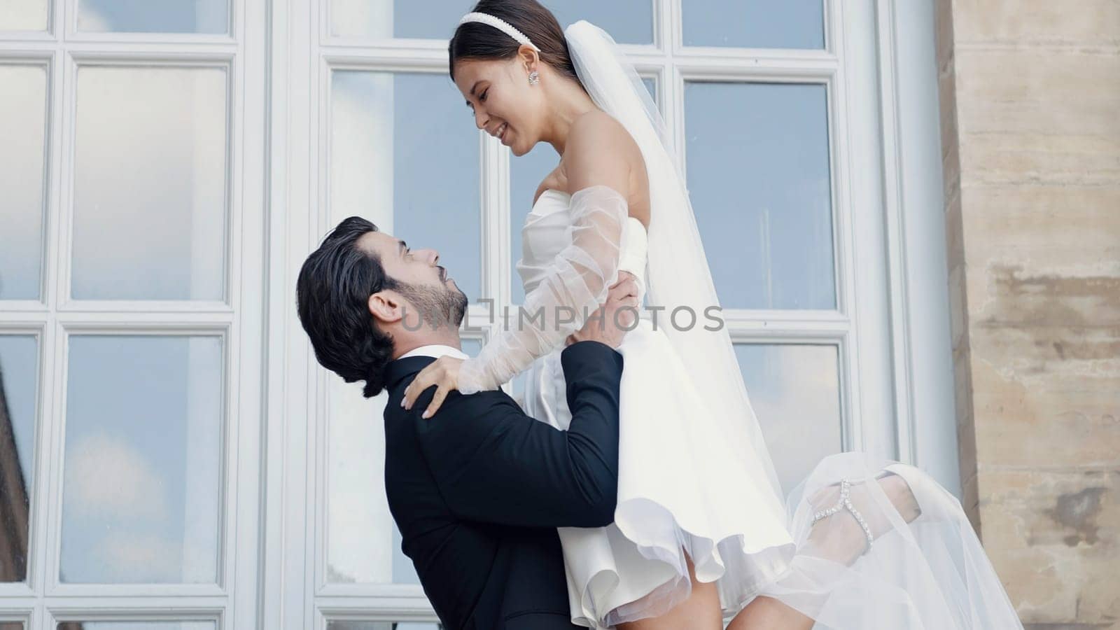 Happy bride and groom in wedding dress and suit. Action. Romantic love of man and woman couple. by Mediawhalestock