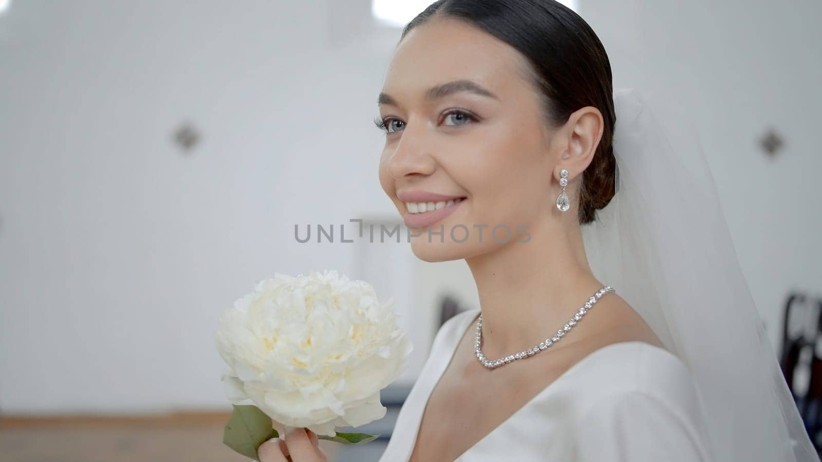 A wedding couple in a church. Action.A young couple is sitting on a decorated chair in wedding costumes and with a wedding white flower. High quality 4k footage