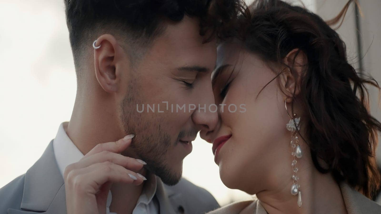 Young kissing couple. Action.Newlyweds with accessories who stand and kiss and communicate and the sea wind blows on them. High quality 4k footage