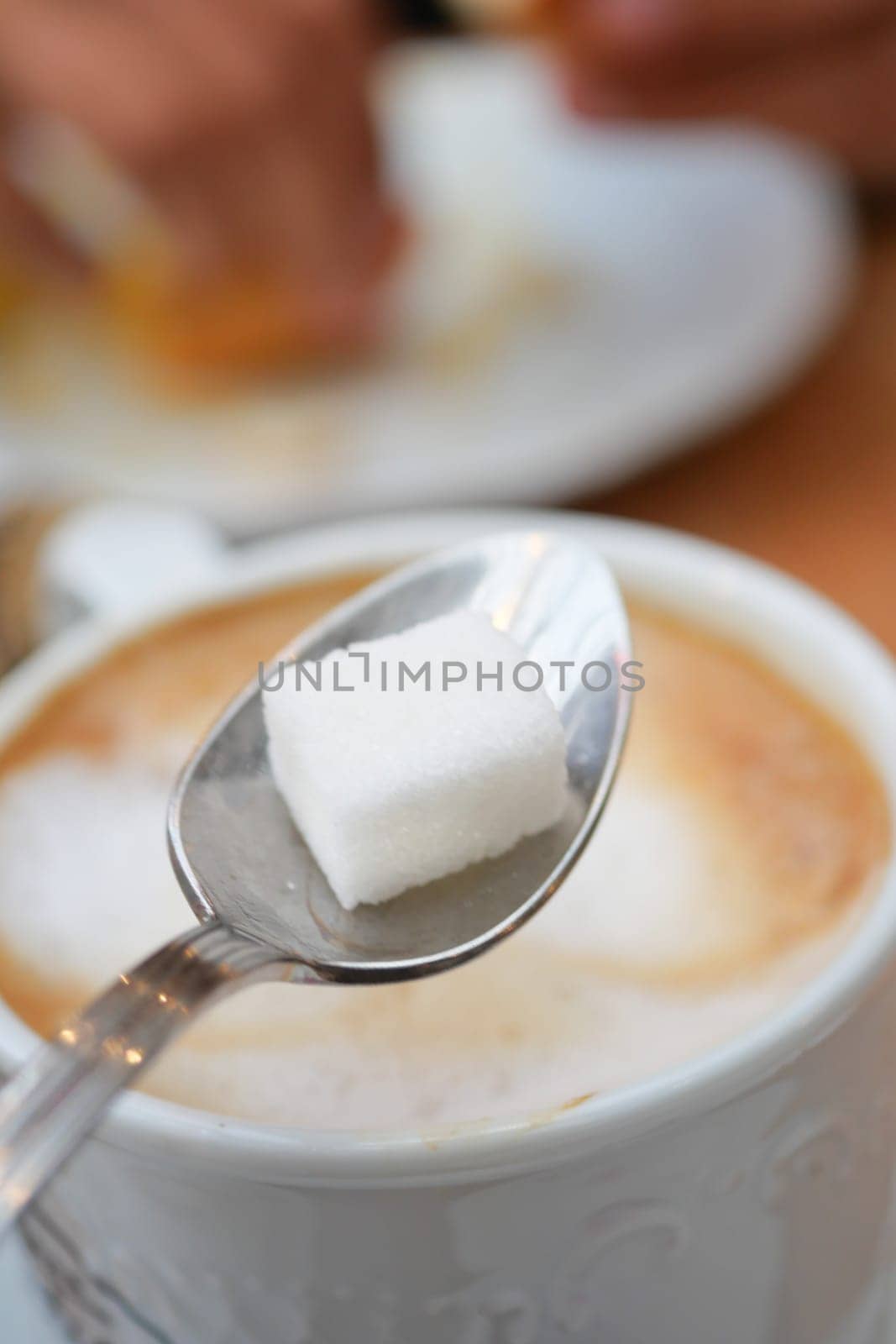 dropping sugar cube in a coffee cup