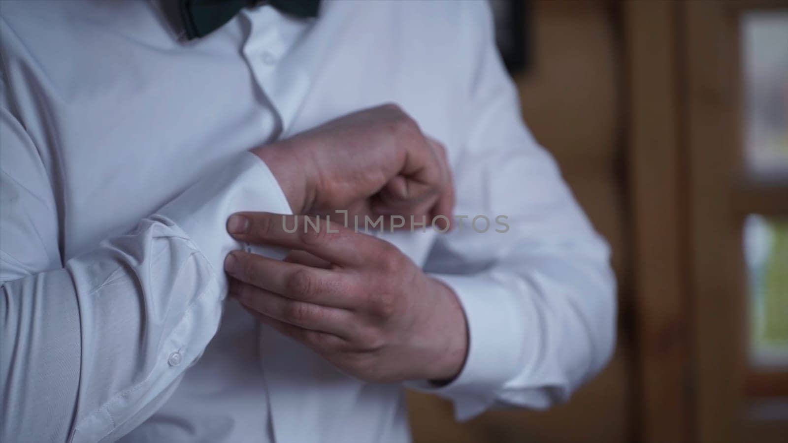 Man buttoning on the sleeves of the shirt. Close up of a hand man how wears white shirt and cufflink. Man buttoning on the sleeve of his shirt. Zip up the cufflink. Men's style HD
