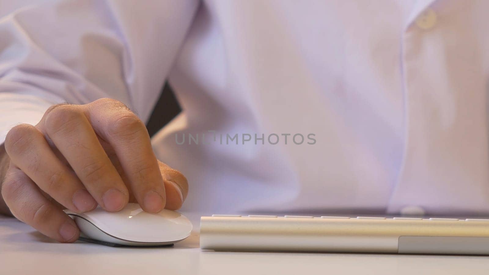 Closeup of a man using computer. His shirt and tie in background.