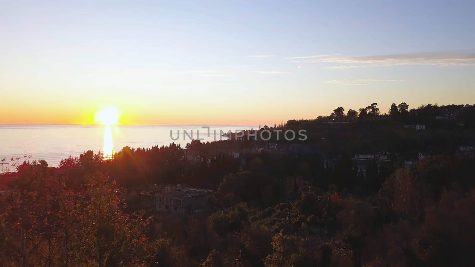 Aerial view - landscape of tree, mountain from the top of mountain in sunset time. Clip. Top view of the mountain city at sunset.