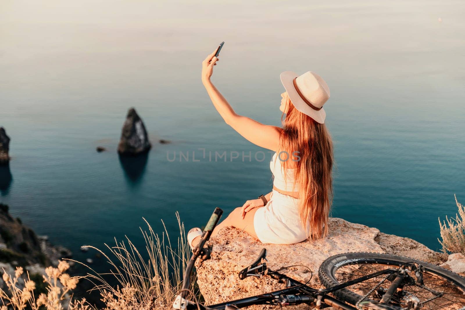 Selfie woman in cap and tank top making selfie shot mobile phone post photo social network outdoors on sea background beach people vacation lifestyle travel concept. by Matiunina