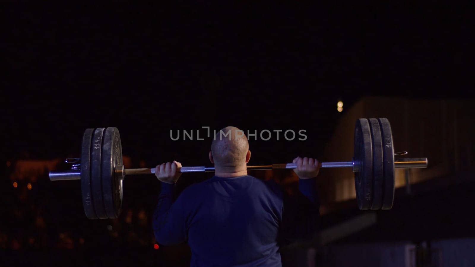 Weightlifter lifts the bar above his head. Strength training with a huge weight. strong crossfit athlete in the middle a heavy snatch lift in a cross-fit box gym 4K