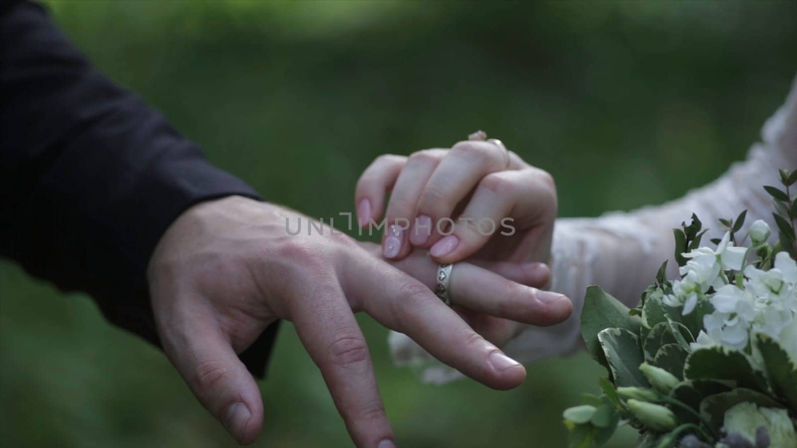 Bride wear ring on groom's finger. The groom puts the wedding ring to finger of the bride. marriage hands with rings. birde wears the ring on the finger of the groom HD