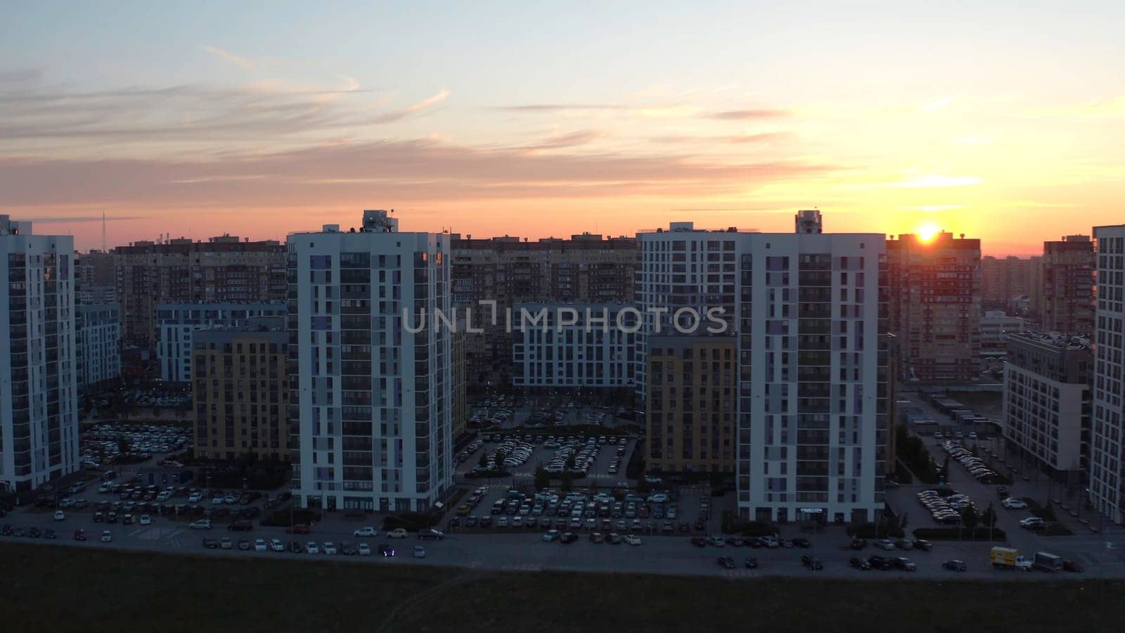Top view of residential area with high-rise buildings at dawn. Stock footage. Picturesque view of complex residential area with sunrise sun. Panorama of residential complexes on background of dawn.