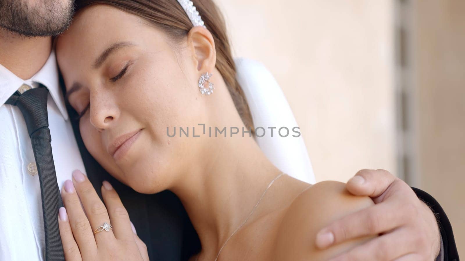 Close-up of bride gently embracing groom. Action. Husband gently embraces beautiful bride. Gentle and reliable embrace of newlyweds by Mediawhalestock