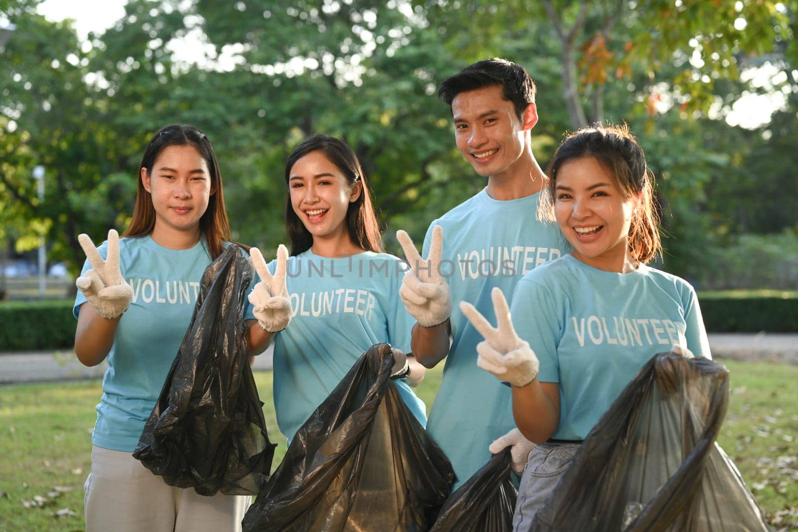 Group of young volunteer collecting trash in the park. Environmental protection and charity concept.