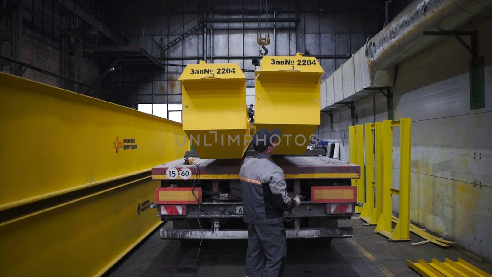 I-beam bridge crane. Clip. Warehouse with large yellow metal beams. Industrial warehouse with overhead crane main beams and truck.
