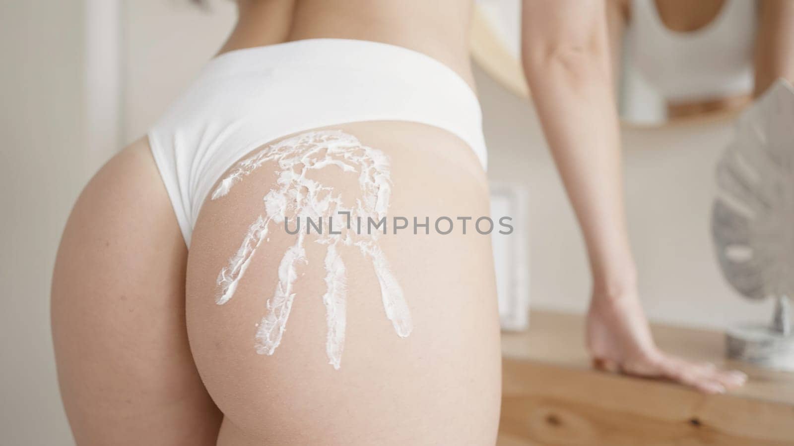 Sexy handprint on woman. Action. Close-up of sexy body of young woman in bright room. Beautiful ass of woman with sexy imprint.